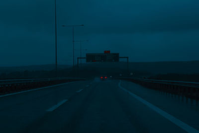 Cars on road against sky at dusk