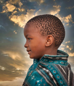 Portrait of teenage boy looking away against sky