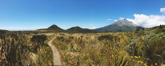 Panoramic shot of land and mt taranaki against blue sky