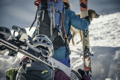 Rear view of hikers holding snowboards on snowcapped mountains during winter