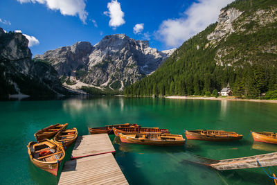 Boats moored over lake against mountains