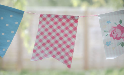 Close-up of buntings hanging against blurred background