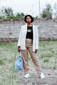 Portrait of smiling young woman standing on field