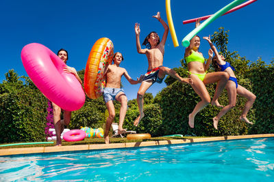 Rear view of woman jumping in swimming pool