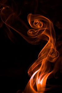 Close-up of orange smoke against black background