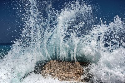 Waves splashing on sea against sky