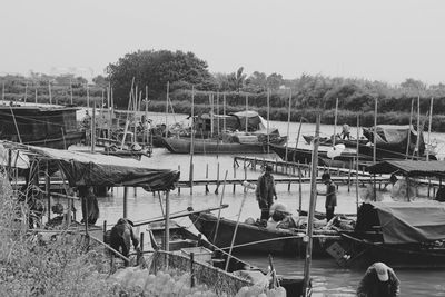 People standing on boats at harbor