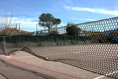 Net on tennis court against sky