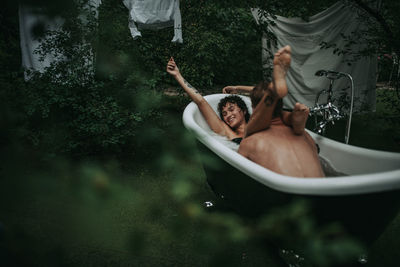 Full length of shirtless man in bathtub