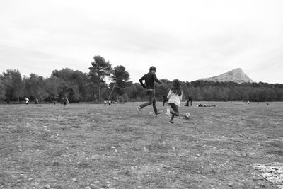 Men playing on field against sky