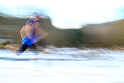 Blurred motion of man surfing in water