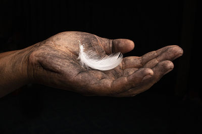 Close-up of man hand against black background