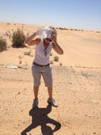 Full length of teenage girl standing on sand dune