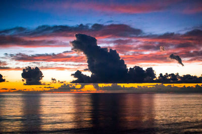Scenic view of sea against dramatic sky during sunset