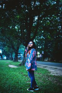 Woman standing by tree in park