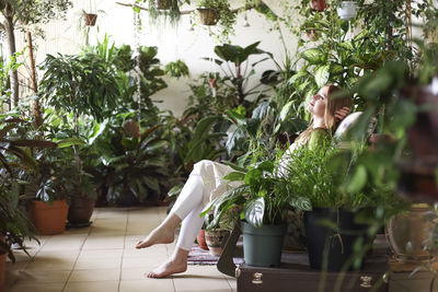 Side view of woman with potted plants