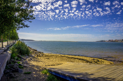 View of calm beach against blue sky