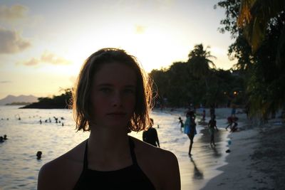 Portrait of young woman at beach during sunset