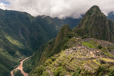 Scenic view of machu picchu and  mountains against cloudy sky