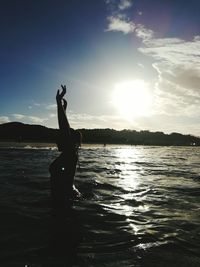 Silhouette man on beach against sky during sunset