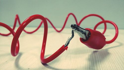 Close-up of red cable on table