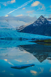 Scenic view of snowcapped mountains by lake against sky