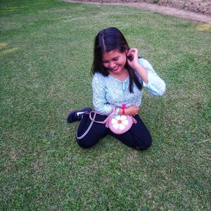 High angle view of smiling woman sitting on grass