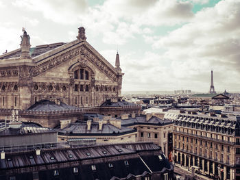 Buildings in city against cloudy sky