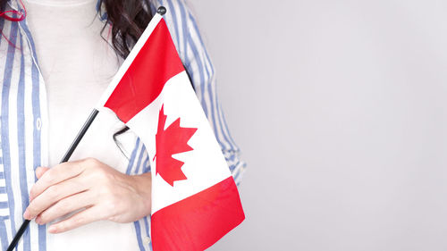 Midsection of woman holding flag against white background