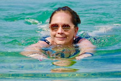 Portrait of smiling woman swimming in pool