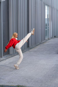 Cheerful african american woman with long blonde hair wearing sportswear and wearing headphones