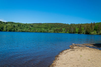 Scenic view of lake against clear blue sky