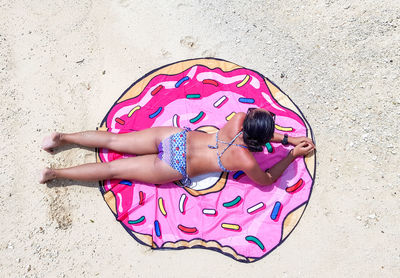 High angle view of woman lying on pink land