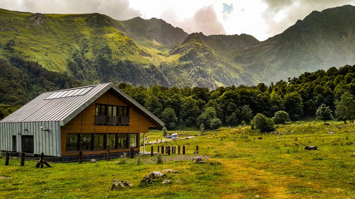 Scenic view of green landscape and mountains against sky