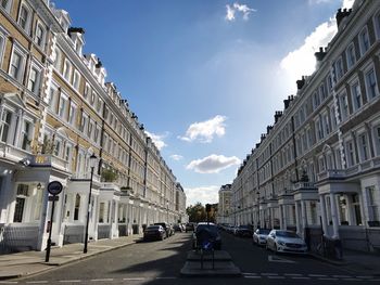 Cars on road in city against sky