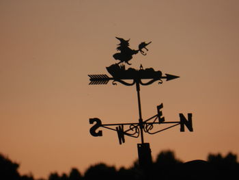 Low angle view of weather vane against clear sky