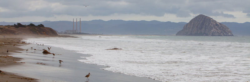 Scenic view of sea and mountains against sky