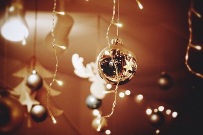 Close-up of christmas ornament on illuminated lighting equipment