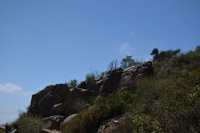 Low angle view of rock formation against clear blue sky