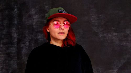 Portrait of teenage girl standing against wall