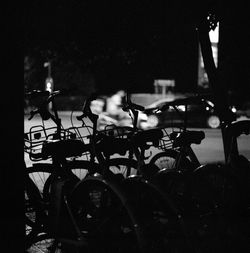 Silhouette people sitting by bicycle at night