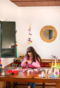 Rear view of woman sitting at home