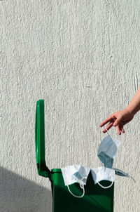 Midsection of woman holding paper against wall