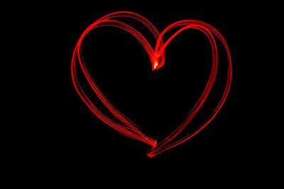 Close-up of red heart shape against black background