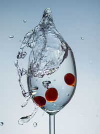 Close-up of water drops on glass against white background