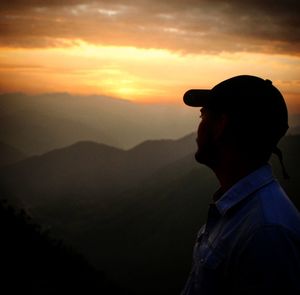 Silhouette man looking at mountain against sky during sunset