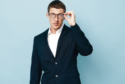 Young man standing against gray background