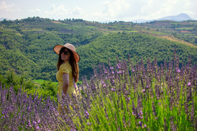 Full length of woman with flowers on field