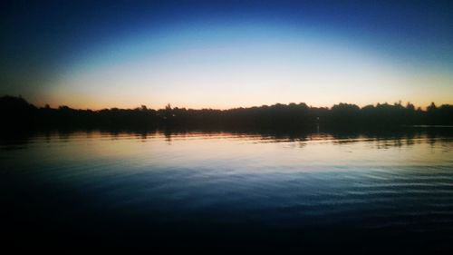 Scenic view of lake against clear blue sky