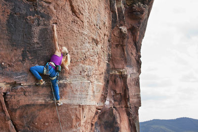Young blonde woman climbing an extreme diffcult rock - veronika frank at rötzenstein - pfalz